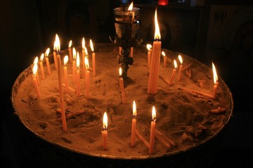 Lighting candles inside a Greek orthodox church.