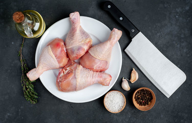 raw chicken legs with spices on a white plate with copy space for your text