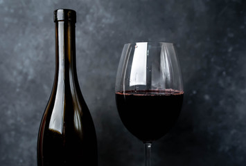 wine bottle and glass with wine on a stone background