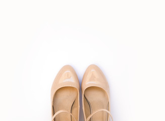 Pale pink female high heel shoes on a white background. Flat lay, top view of fashionable beauty female background.