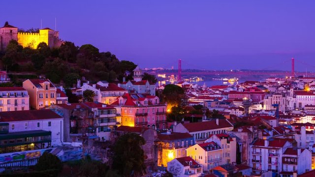 Lisbon, Portugal. Aerial view of Lisbon, Portugal at sunrise with view over old Alfama and castle. Time-lapse from dark to light, zoom in