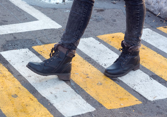 Women's feet on a pedestrian crossing. Shoes, boots, go, walk. Asphalt, markings, mud, puddles....