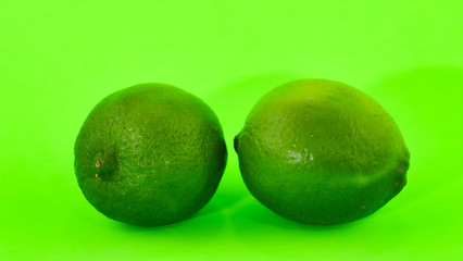 Deux limes sur un arrière plan de couleur vert fluorescent.