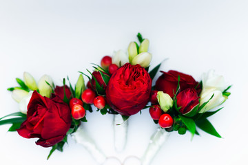 boutonniere with red roses on a white background. top view