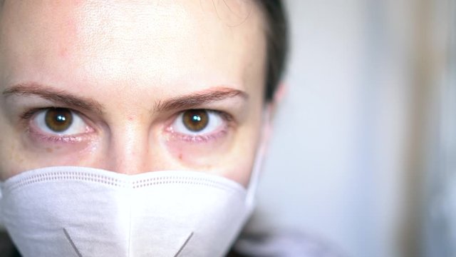Woman face close up eyes sad. Female wearing respirator and tears on her eyes.