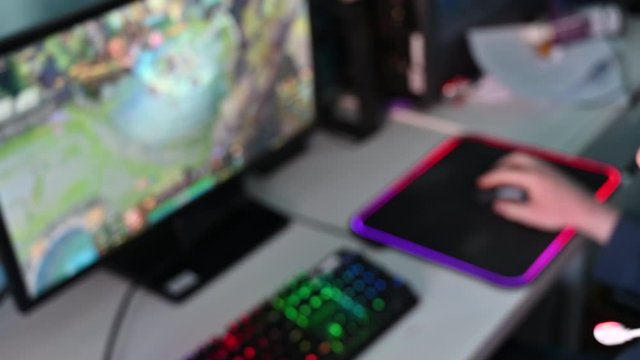 Hand of a person playing computer game using an LED mouse pad