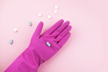 Woman hand in protective gloves with pills.