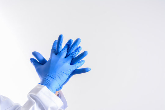 Doctor putting on sterile gloves isolated on white. scientist wearing glove. Human wearing glove on white background. blue rubber glove on a man hand isolated on white