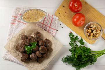Homemade fried meatballs with herbs on a white background. Swedish traditional cuisine. Top view