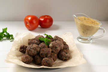 Homemade fried meatballs with herbs on a white background. Swedish traditional cuisine.