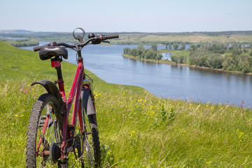 mountain bike on the high bank of the river Kama, view of the river Kama and water meadows