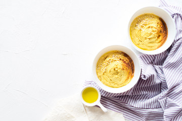 Home made hummus bowl with olive oil and red paprika isolated on white background. Oriental food. Top view. 