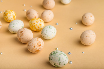 Easter background with beige marzipan eggs on beige background