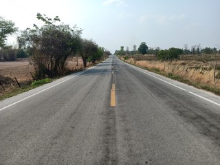 Fototapeta na wymiar Asphalt roads in Thailand and yellow traffic lines