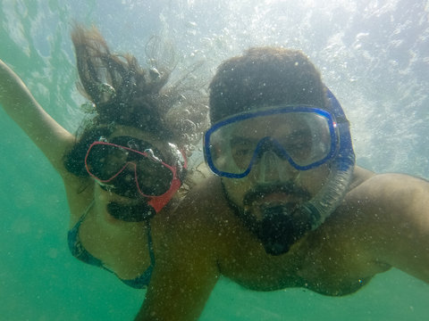 casal mergulhando de m&aacute;scara e snorkel no mar