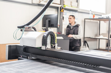 Technician works on large CNC computer numerical control cutting machine