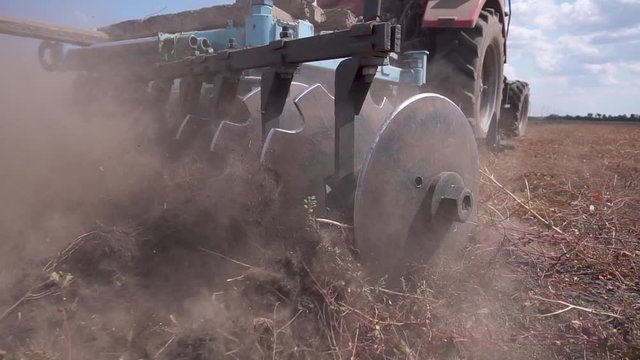 Tractor plows the ground garden agricultural tractor farm equipment. Tractor disc ground.