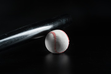Baseball game equipment on dark black background close up
