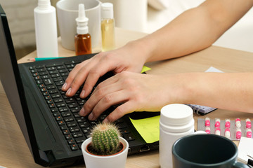 Hands typing on laptop keyboard in an office close up