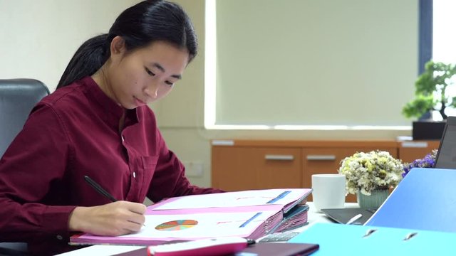 Asian business women are signing Approving file folder on office, efficiency and productivity concept
