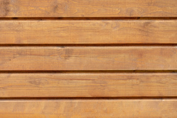 the empty wooden background is dark orange. The boards are positioned horizontally. Knots on the wood surface.