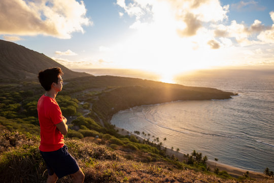 Man looking off to the horizon - future - Hanama Bay sunrise - golden hour - over pacific ocean