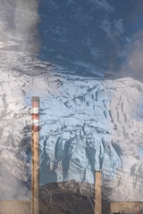 Double exposure of Cooling towers and Chimneys of a coat-fired power plant fuming white smoke with blue sky background and the retreat of glacier in the Alps. Climate change.