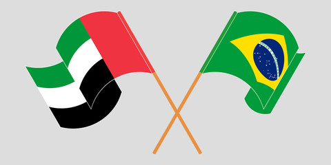 Crossed and waving flags of Brazil and the United Arab Emirates