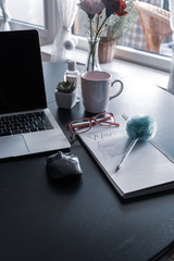 Working from home concept with  a laptop keypad with coffee cup, mouse and notepad with workfrom home written on a dining table