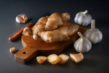 Ginger root and garlic on a wooden background are natural remedies for the virus. Low key