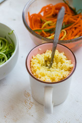 Cooked couscous durum wheat grain porridge in cup. Crushed semolina millet. Vegan healthy food.