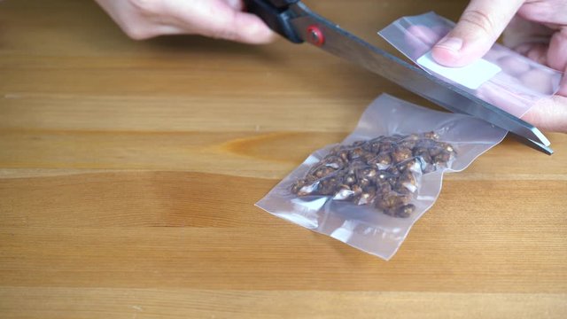 Vacuum bag with magic truffles, a hands take the package and open it. She takes the mushrooms out of the bag and shows them.The Psilocybe Mexicana is the most well-known psilocybin mushroom.