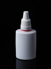 White plastic medical container on white, black background..nasal spray