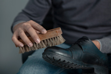 Fototapeta premium man cleans his shoes with a brush