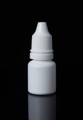 White plastic medical container on white, black background..eye drops
