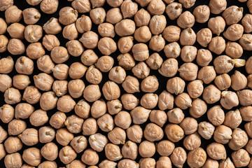 a lot of dried chickpeas for making hummus on a black background