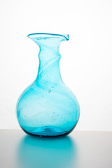 Silhouette of an empty blue turquoise bottle, vase, against white background with reflection in Zurich, Europe, Switzerland.