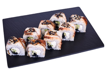 japanese sushi rolls on a black stone Black Dragon on a white background. Roll ingredients: eel, philadelphia cheese, avocado, unagi sauce, black tobik caviar, sesame mix, nori, rice.