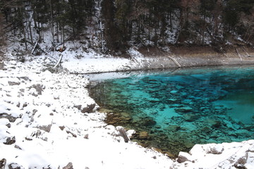 beautiful landscape of a lake in Jiuzhaigou national park, Sichuan China with snow and reflection of the trees in the water