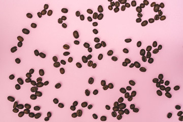 Coffee beans on a pink paper background