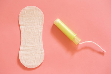 Menstrual cycle.  White female pad and tampons on a pink background.