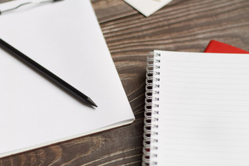 Close-up of a black tablet with a sheet of notepads and glasses with coffee on a wooden table with a blurred background. office Desk concept.