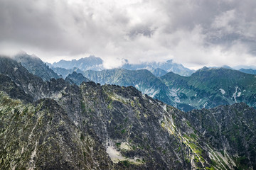 Fototapeta na wymiar View onto the rugged mountain range of High Tatras seen from the peak of Jahňací štít down on an overcast, summer day. Scenic Slovakian Tatra landscape.