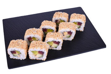 Traditional fresh japanese sushi rolls on a black stone Theca Spicy on a white background. Roll ingredients: tuna, daikon radish, cucumber, spicy sauce, nori, rice, white sesame seeds.