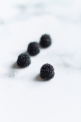 small black berries blackberries on a light background close up