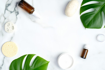 Frame of natural SPA cosmetics on marble background. Organic beauty products for skincare, body and hair care with tropical leaf. Beauty treatment concept. Flat lay, top view, copy space