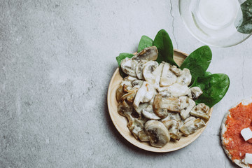 Fresh mushrooms with tomatoes on grey background. Vegan healthy food concept