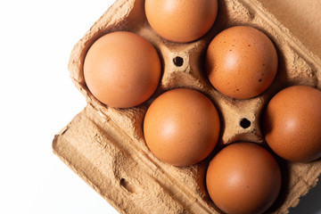 Half dozen brown eggs with eggs carton