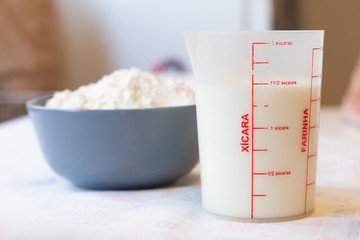 Milk and flour, basic ingredients. Cup unit in portuguese