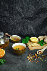 Ginger tea with lemon, honey and mint on grey concrete background. Top view, flat lay, copy space